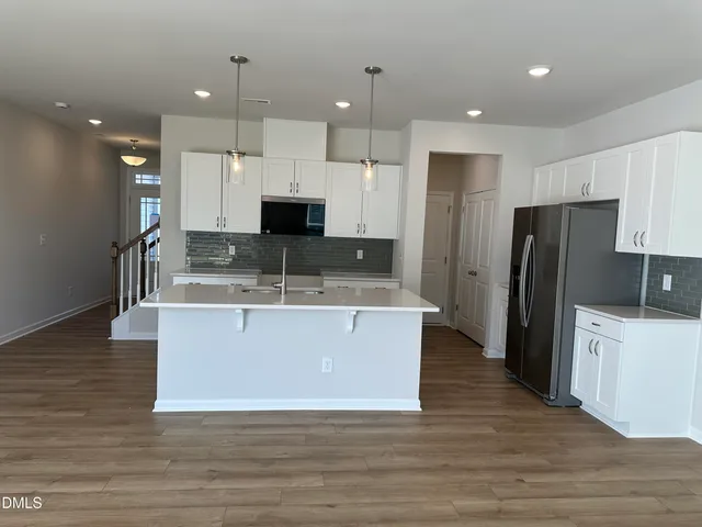 a large kitchen with kitchen island a sink a center island stainless steel appliances and a center island