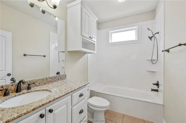 a bathroom with a granite countertop sink a toilet and a bathtub