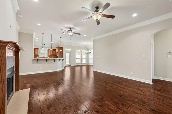 a view of a room with wooden floor and a kitchen
