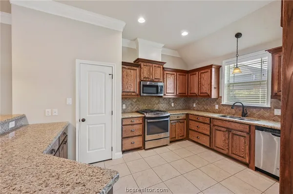a kitchen with stainless steel appliances granite countertop a sink and a stove