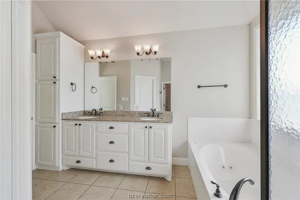a bathroom with a granite countertop sink a mirror and a bathtub