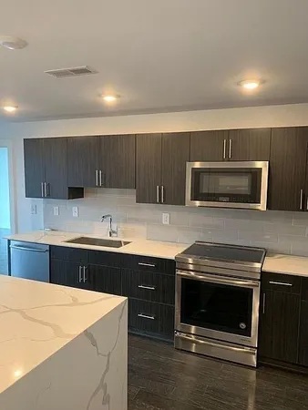 a kitchen with a sink and steel appliances
