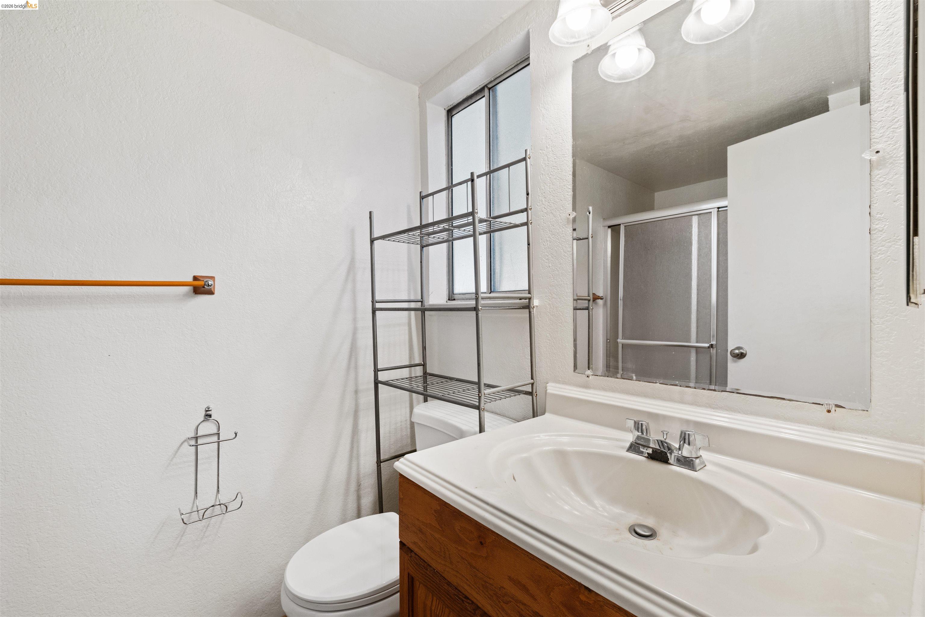 1151 Chadwick Circle Bay Point, CA 94565 - Photo 17 of 23 Bathroom featuring a single vanity with wood-finish cabinetry, a white countertop, and a chrome faucet