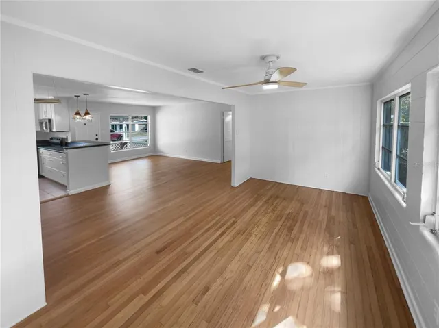 a view of empty room with wooden floor