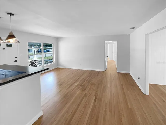 a view of a kitchen with wooden floor and a window