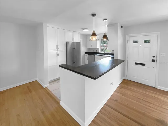 a kitchen with stainless steel appliances granite countertop a sink a stove and a wooden floors