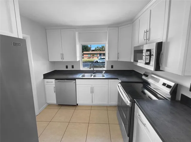 a kitchen with a sink a stove and cabinets