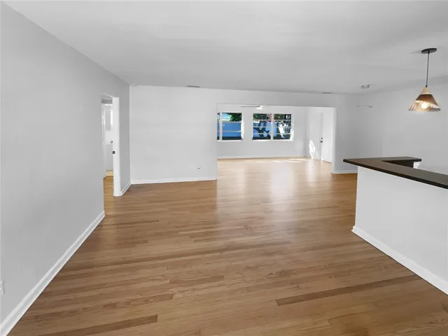 a view of a room with wooden floor and a hallway