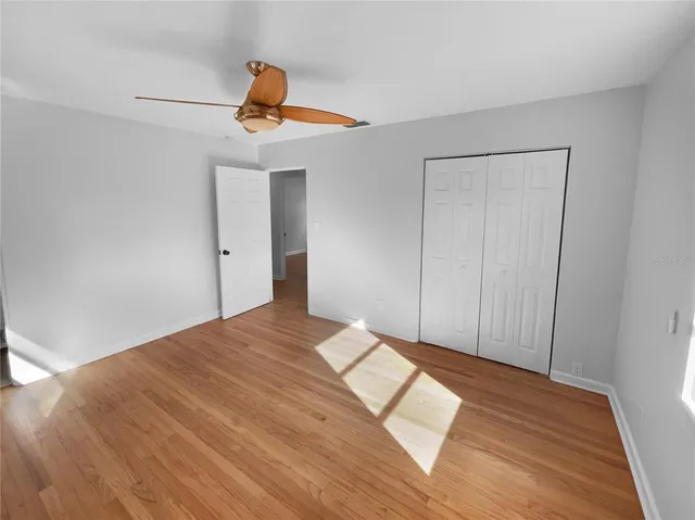 a view of a livingroom with wooden floor and ceiling fan