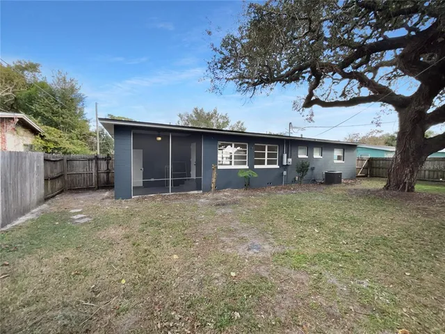 a front view of a house with a garden and tree