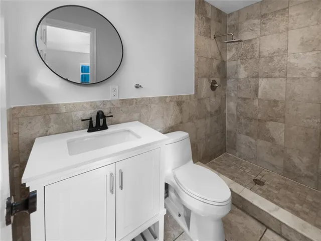 a bathroom with a sink a toilet and a mirror