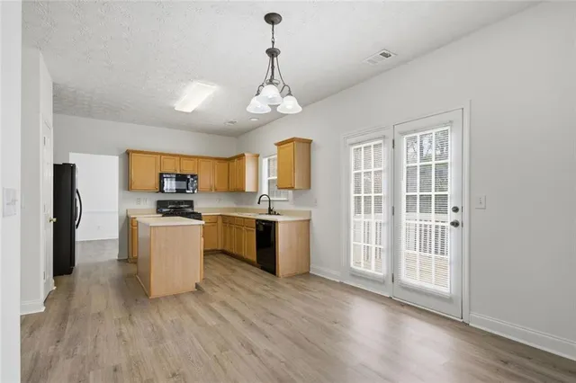 a view of kitchen with granite countertop stove top oven and cabinets