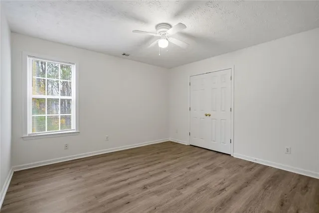an empty room with wooden floor and windows