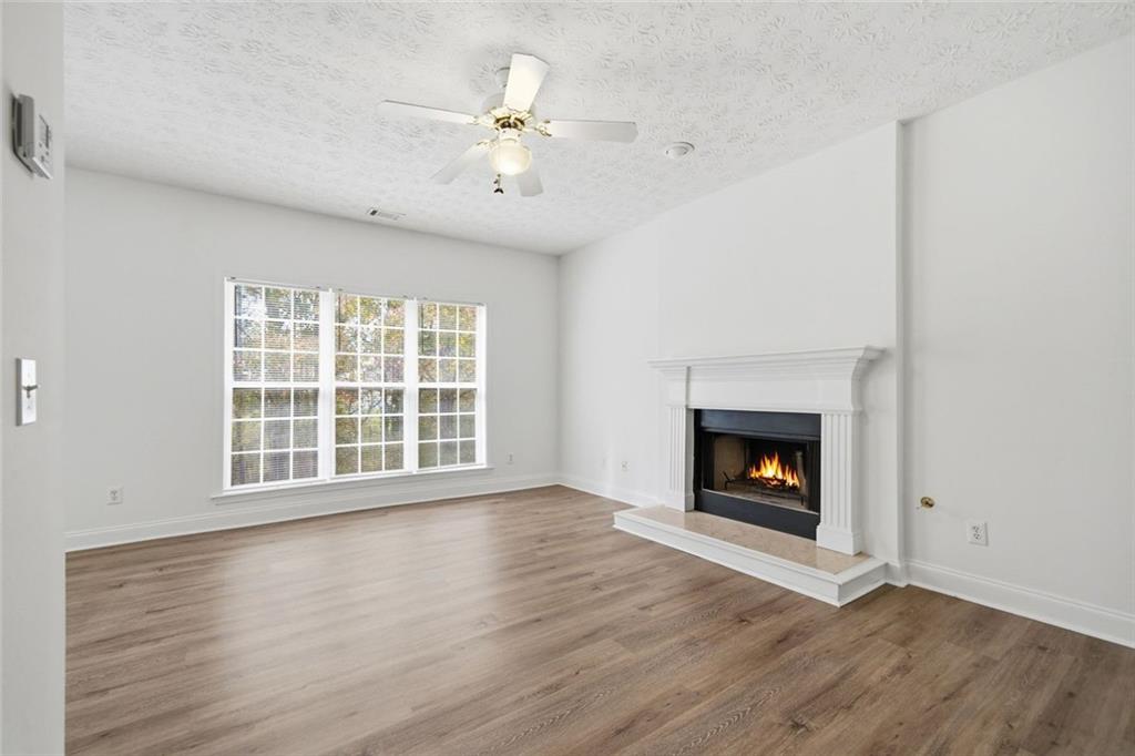2254 Caneridge Trail Southwest Marietta, GA 30064 - Photo 10 of 30 an empty room with wooden floor fireplace and windows