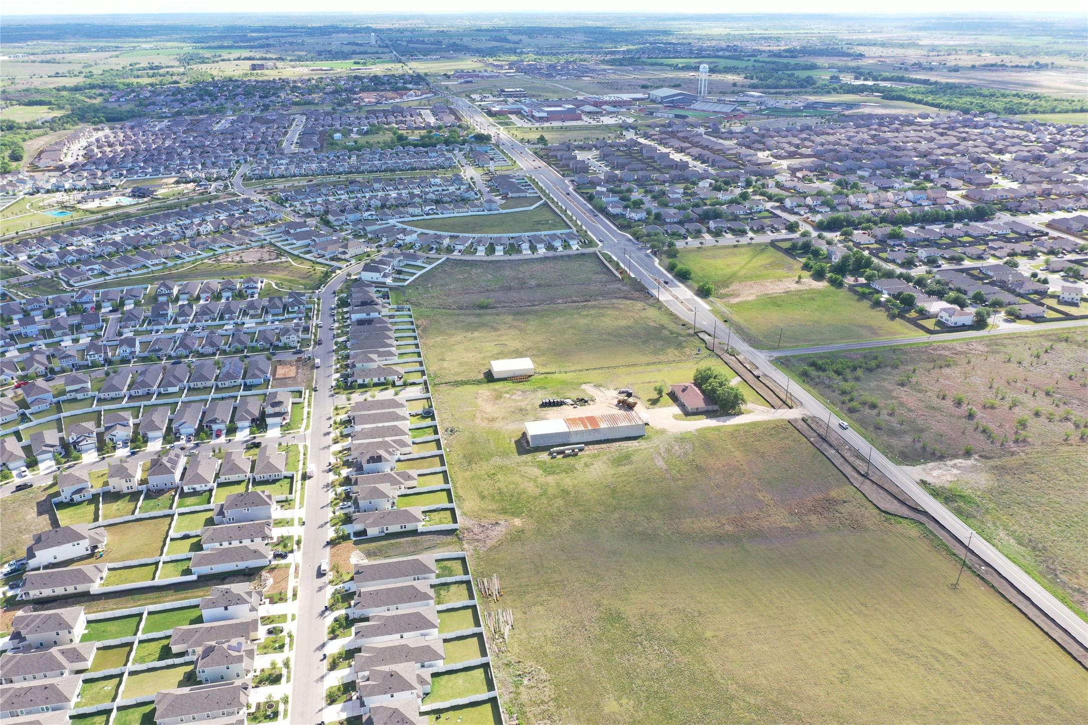 14601 County Line Road Elgin, TX 78621 - Photo 5 of 5 An aerial perspective reveals a vast land parcel ripe for development amidst established residential areas and open fields.