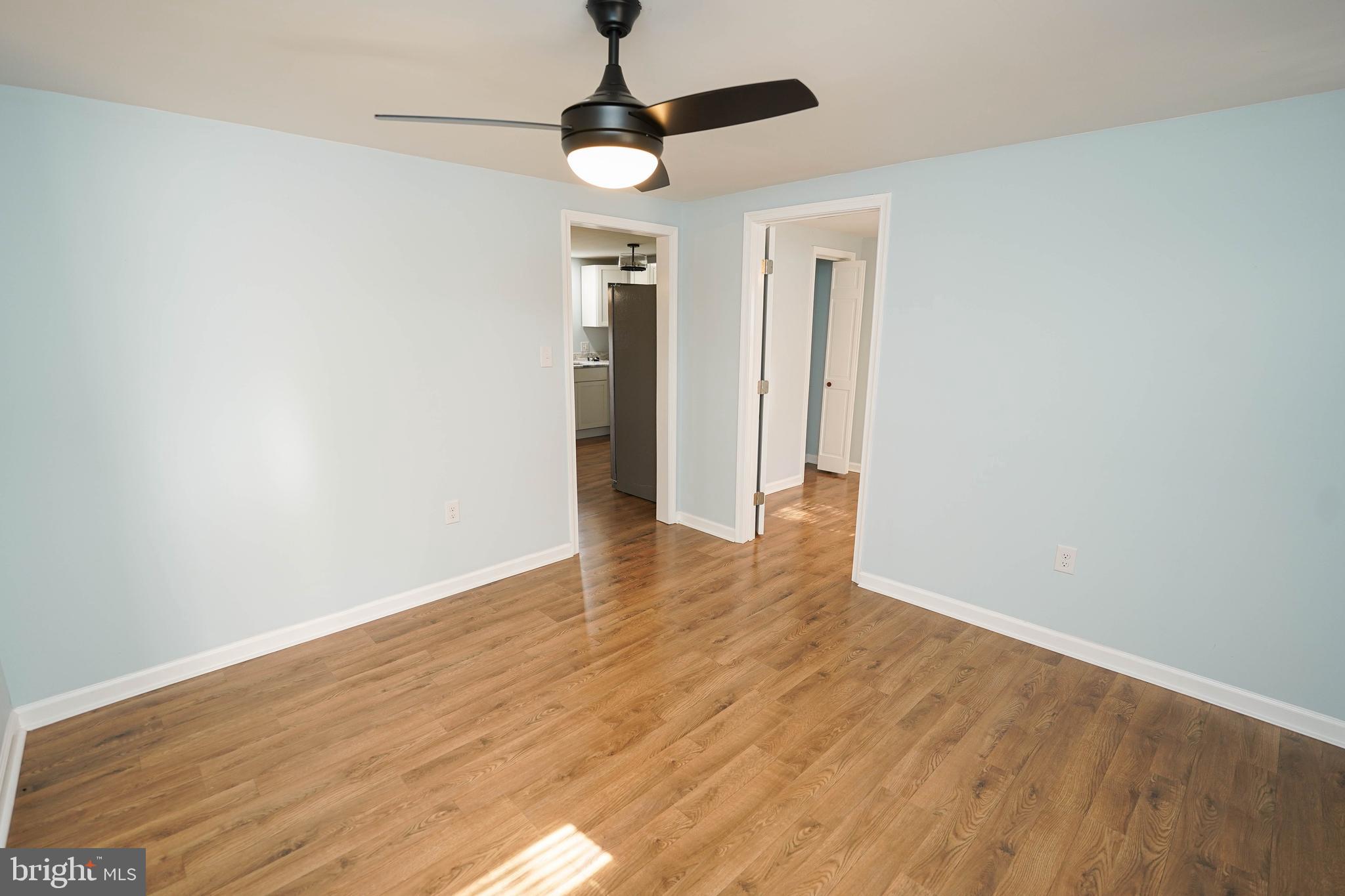 31872 Flower Hill Church Road Eden, MD 21822 - Photo 4 of 28 a view of an empty room with wooden floor and a ceiling fan