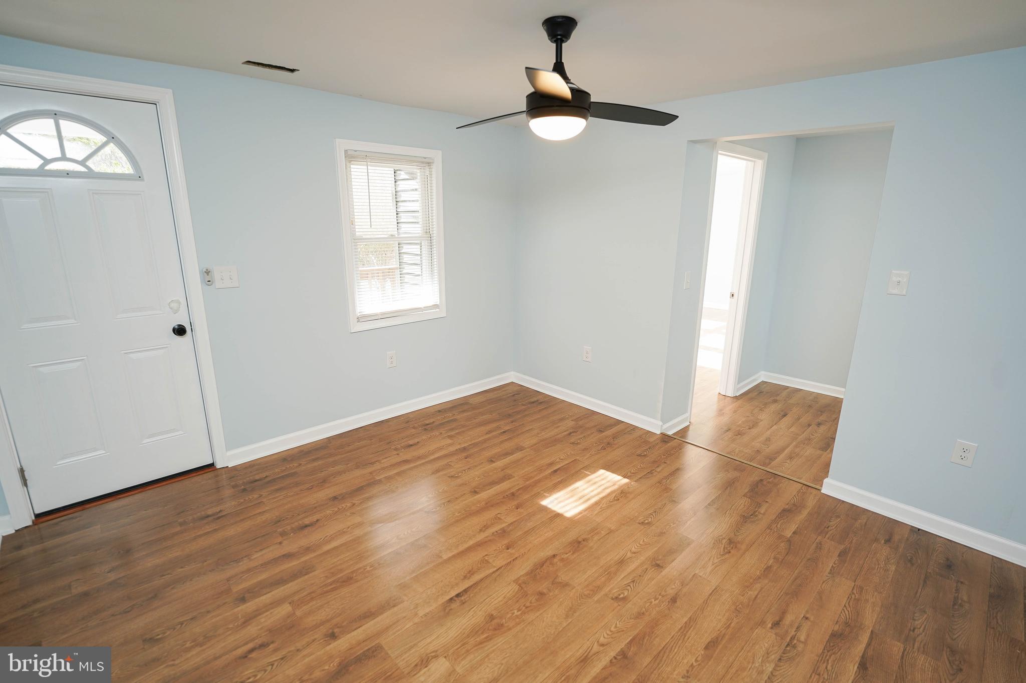 31872 Flower Hill Church Road Eden, MD 21822 - Photo 6 of 28 an empty room with wooden floor fan and windows