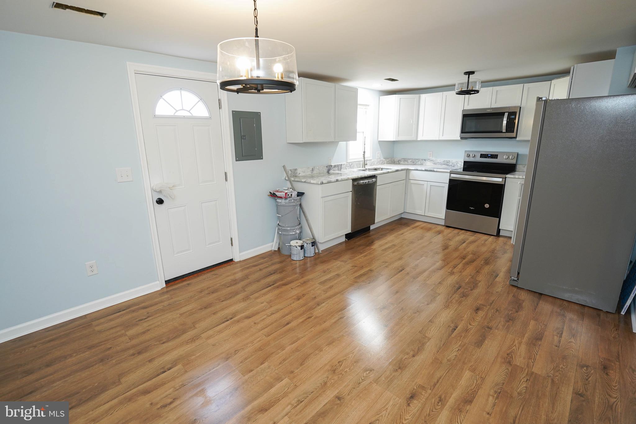 31872 Flower Hill Church Road Eden, MD 21822 - Photo 8 of 28 a kitchen with granite countertop a refrigerator a stove a microwave and wooden floor