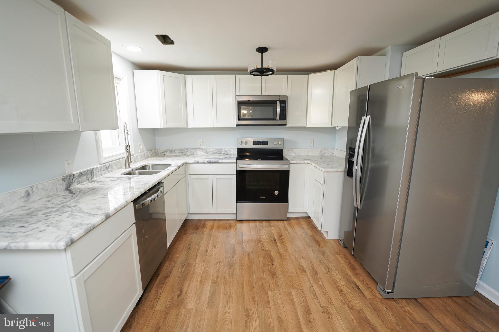 31872 Flower Hill Church Road Eden, MD 21822 - Photo 10 of 28 a kitchen with stainless steel appliances granite countertop a refrigerator a sink dishwasher a stove with wooden floors