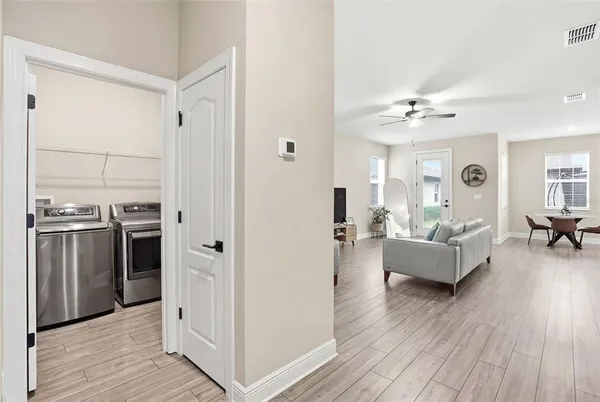 a living room with stainless steel appliances furniture and a wooden floor