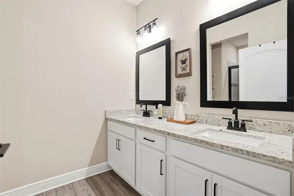 a bathroom with double vanity and a mirror