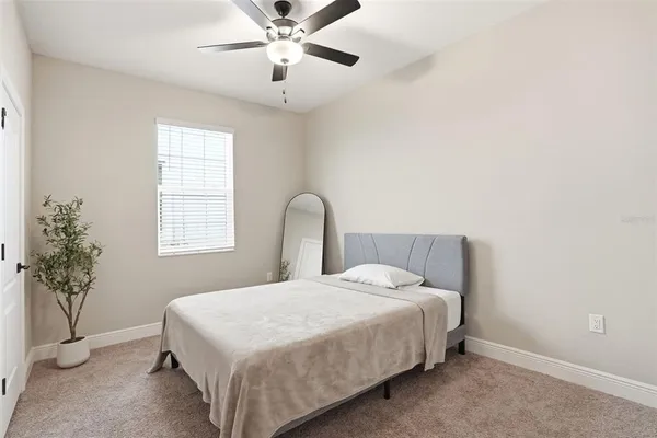 a bedroom with a bed and a potted plant