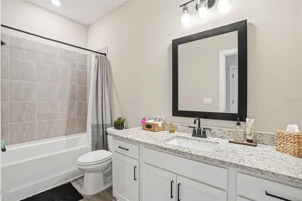 a bathroom with a granite countertop sink toilet and shower