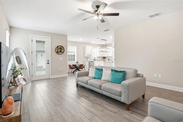 a living room with furniture and a wooden floor