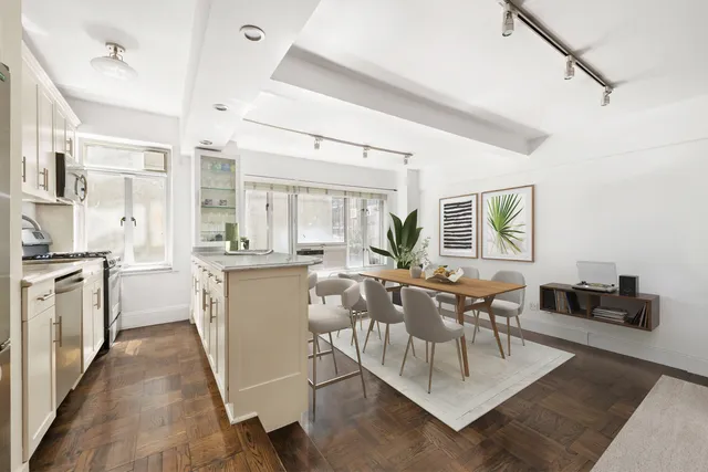 a dining room with kitchen island stainless steel appliances furniture and a dining table