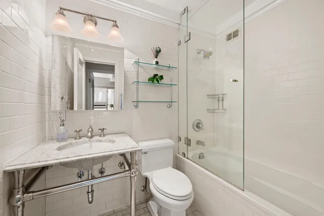 a bathroom with a sink toilet vanity and shower