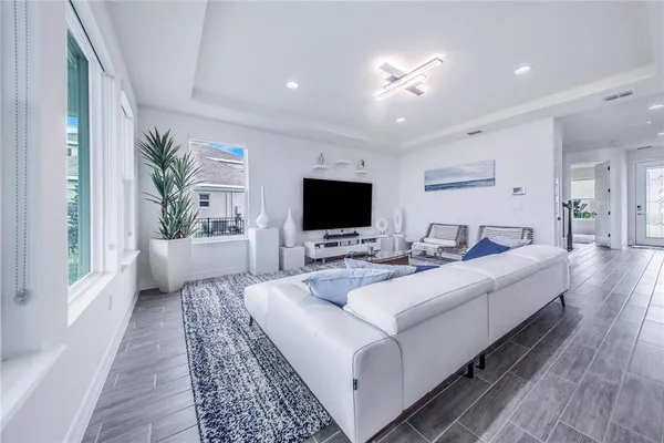 a kitchen with kitchen island stainless steel appliances a dining table chairs sink and microwave
