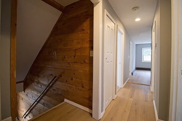 a view of a hallway with wooden floor and staircase