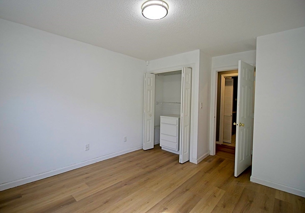 45 Depot Street, Unit 2 Sharon, MA 02067 - Photo 7 of 12 an empty room with wooden floor and closet