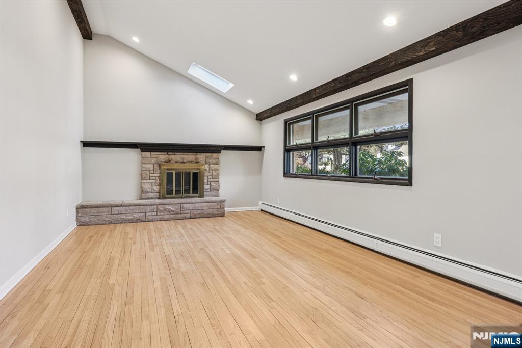 217 Knickerbocker Road Closter, NJ 07624 - Photo 5 of 27 an empty room with wooden floor fireplace and windows