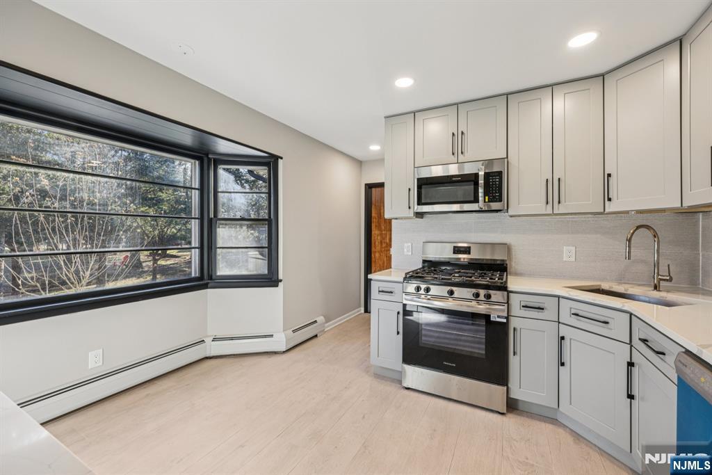 217 Knickerbocker Road Closter, NJ 07624 - Photo 9 of 27 a kitchen with stainless steel appliances a stove sink and microwave