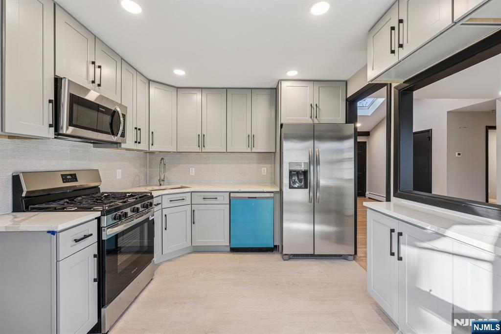 217 Knickerbocker Road Closter, NJ 07624 - Photo 10 of 27 a kitchen with stainless steel appliances granite countertop a stove a sink and a refrigerator