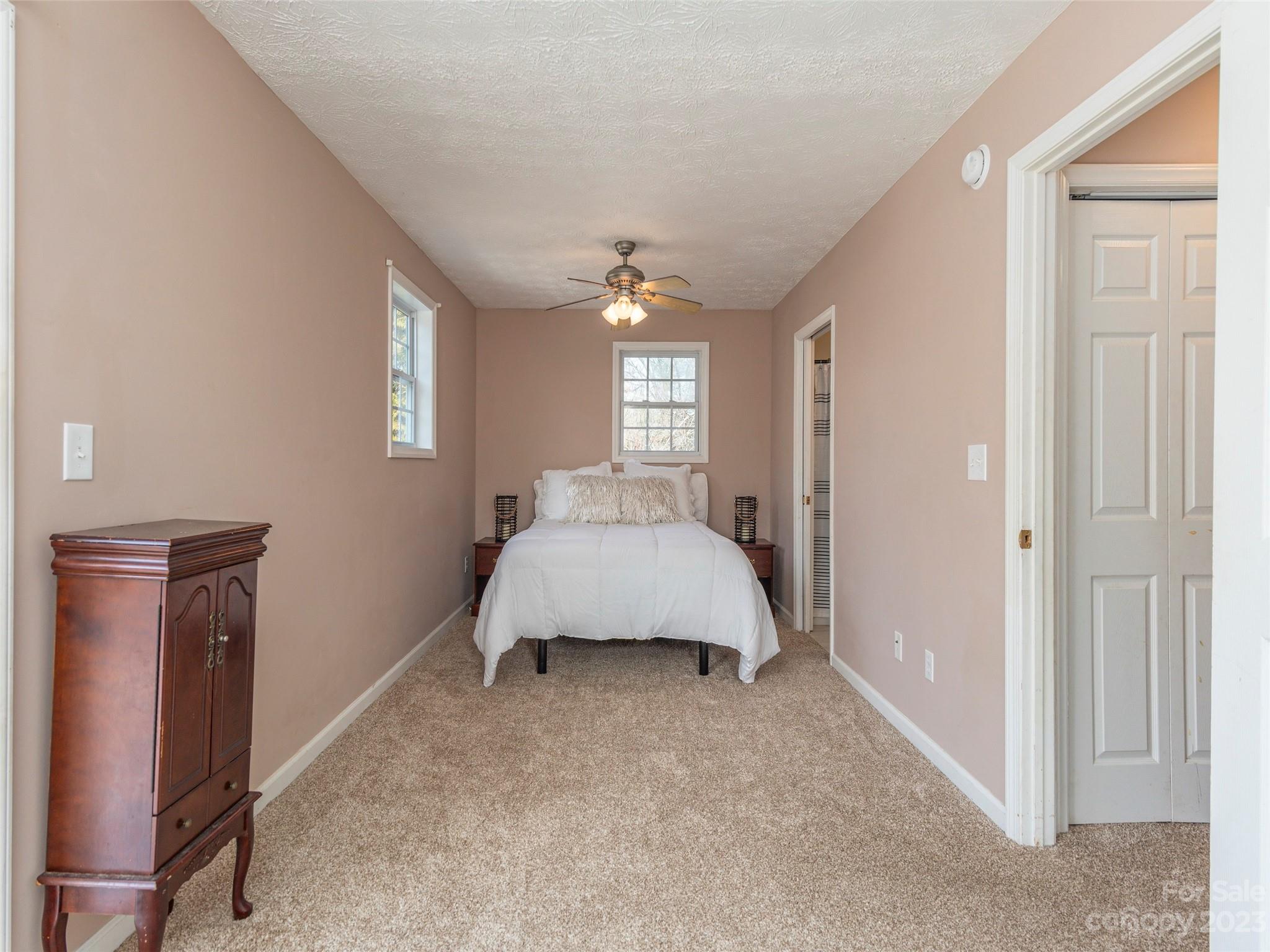 40 Laurel Loop Asheville, NC 28806 - Photo 19 of 26 a spacious bedroom with a bed and a chandelier