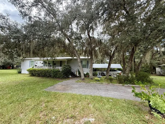 a view of a house with backyard and sitting area