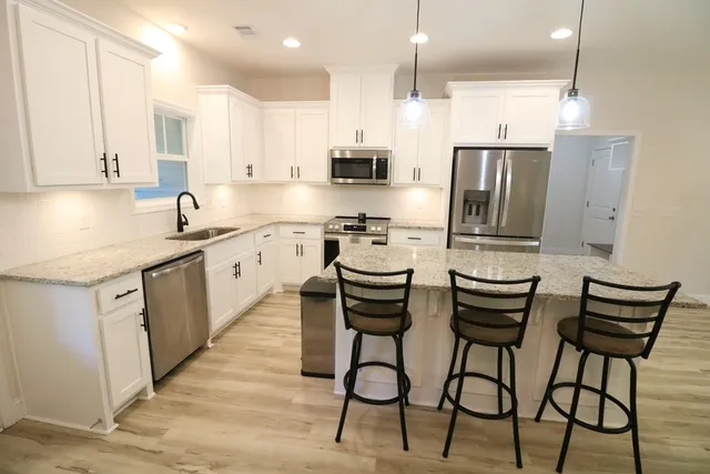 a kitchen with stainless steel appliances kitchen island granite countertop a sink and cabinets