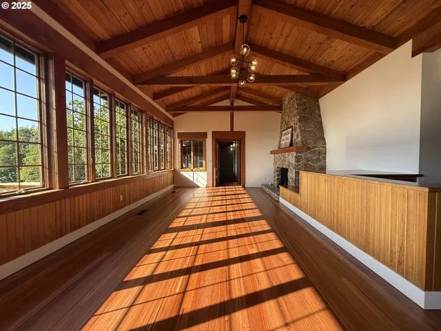 a living room with stainless steel appliances granite countertop couches a fireplace with wooden floor