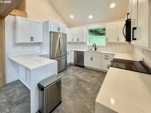 a kitchen with a sink a counter top space stainless steel appliances and cabinets