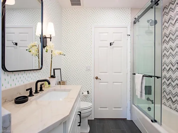 a bathroom with a sink and mirror with toilet