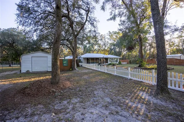 a view of a house with backyard and trees