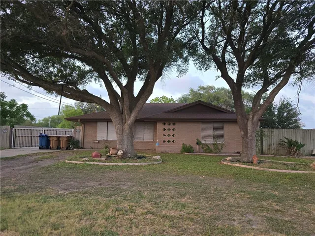 a front view of house with yard and trees