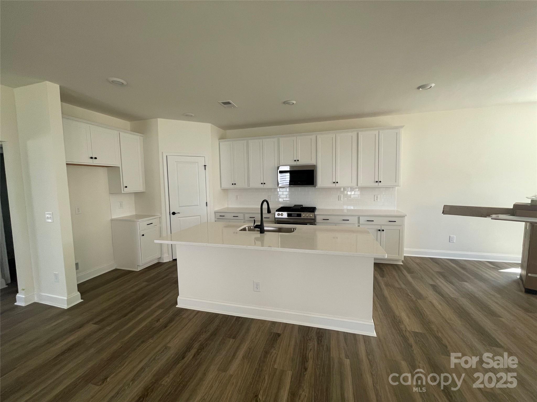 4044 Grommet Court Matthews, NC 28105 - Photo 15 of 27 a kitchen with wooden floors and white appliances