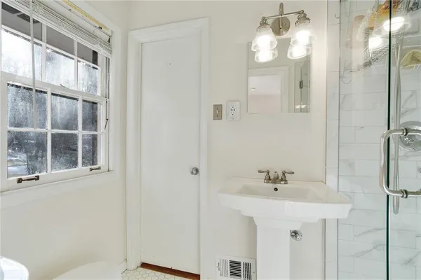 a bathroom with a sink a mirror and a shower
