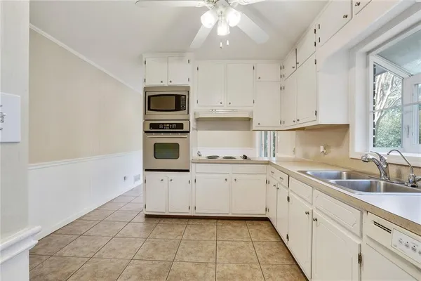a kitchen with granite countertop a sink a stove and cabinets