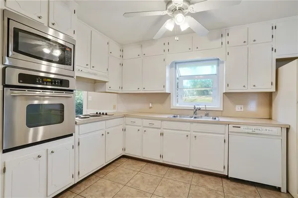 a kitchen with cabinets appliances a sink and a window