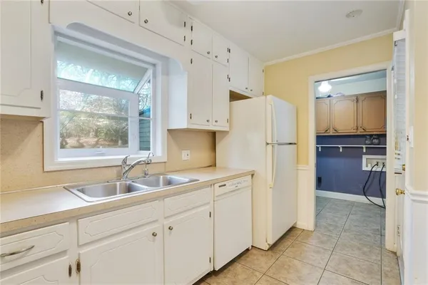 a kitchen with white cabinets and refrigerator