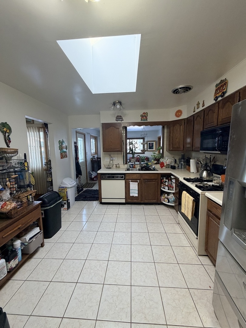 9013 Oriole Avenue Morton Grove, IL 60053 - Photo 10 of 17 a large kitchen with cabinets and stainless steel appliances